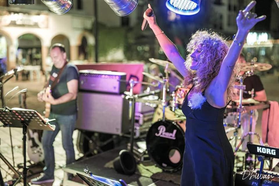 Une femme debout sur une scène avec ses bras dans l'air dans l'établissement Camping Le Bois De Pins, à Salses-le-Chateau 37 autres photos