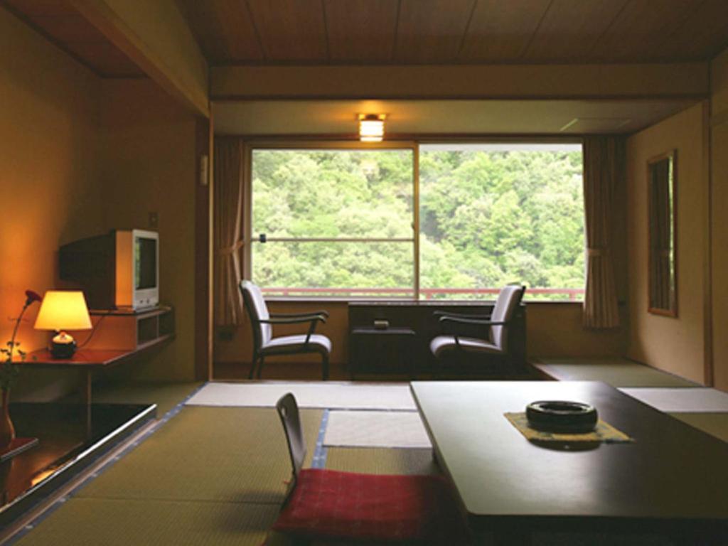 un salon avec une table et des chaises et une fenêtre dans l'établissement Ookawaso, à Aizuwakamatsu