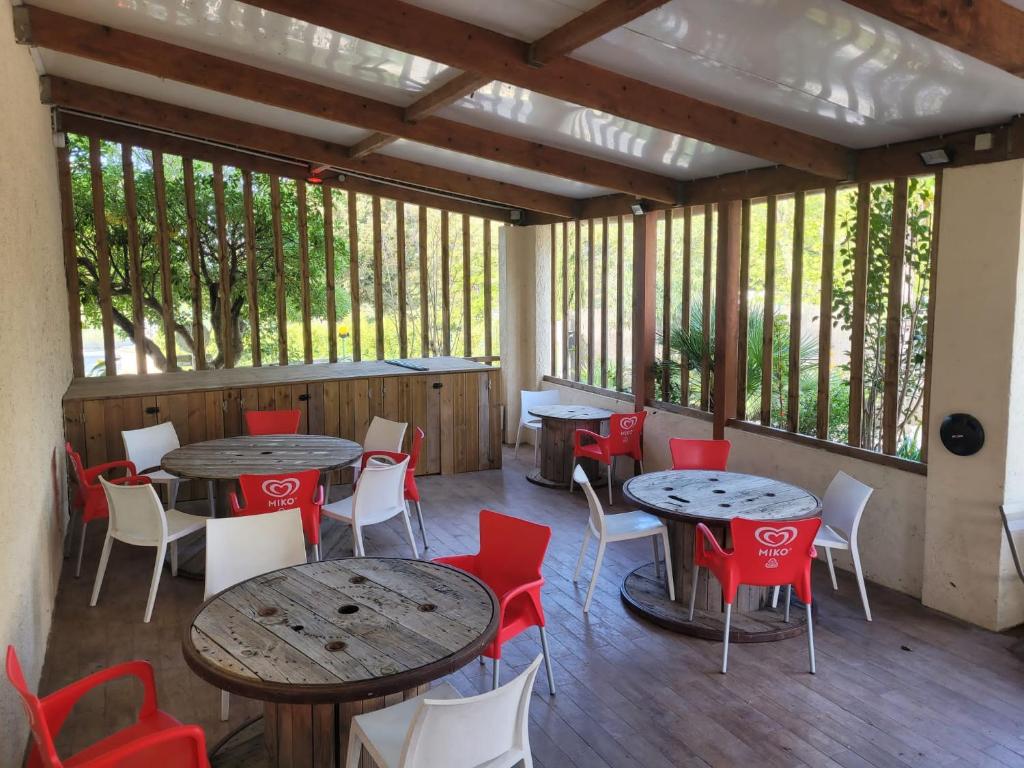 une véranda avec des tables et des chaises dans l'établissement Eco-Lodge Lou Pantaï, au Pradet