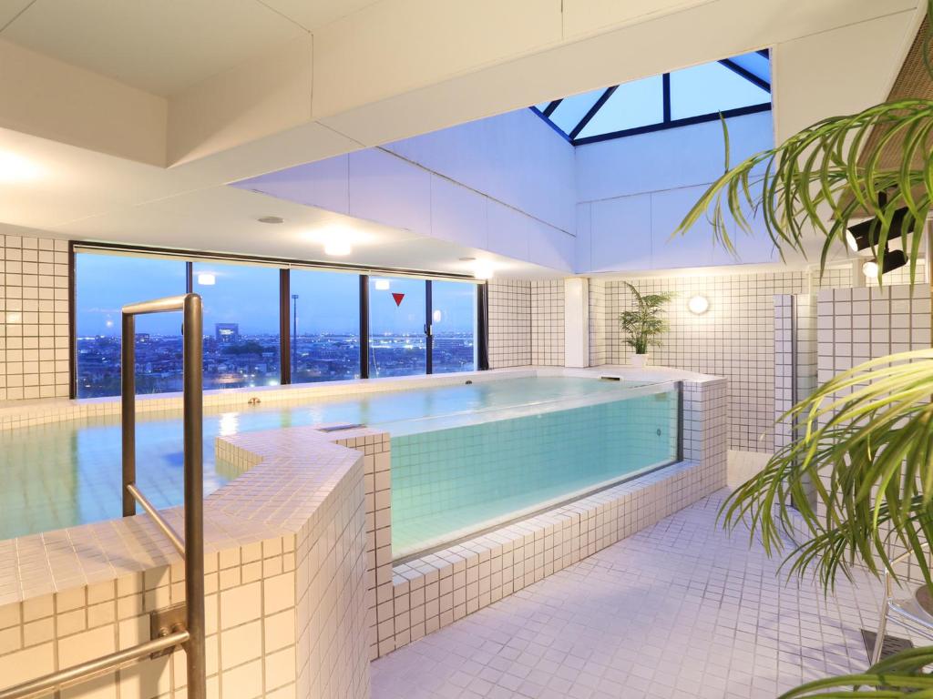 - une piscine dans une maison avec une grande fenêtre dans l'établissement G HOTEL 一宮 -Hotel & Resorts-, à Inazawa