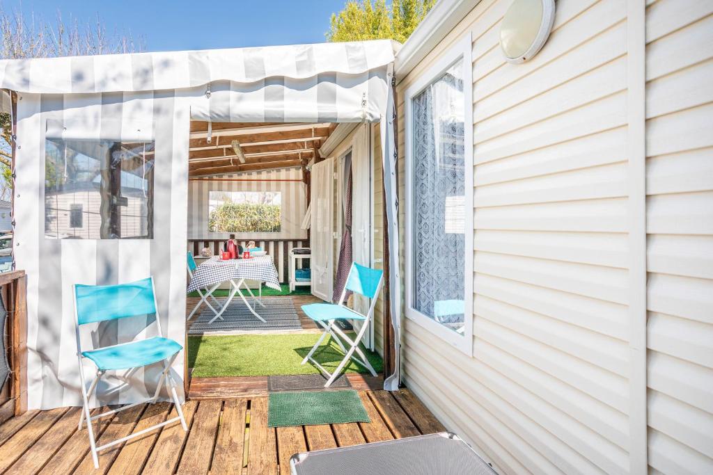 un patio avec deux chaises et une table sur une terrasse dans l'établissement Mobilhome au calme - piscine, à La Parée Preneau