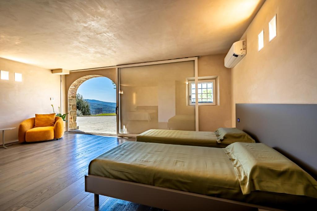 une chambre avec deux lits et une fenêtre et une chaise dans l'établissement YD exclusive design villa Agati, à Castiglion Fiorentino 74 autres photos