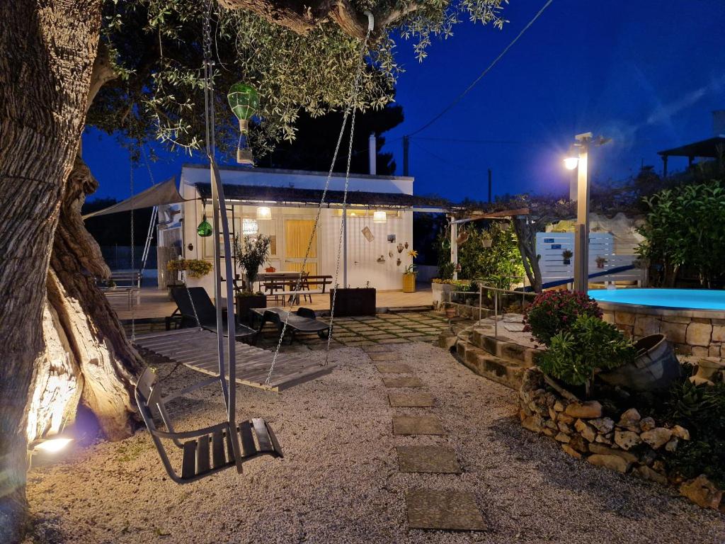 une balançoire suspendue à un arbre à côté d'une maison dans l'établissement Villa Anna Polignano, à Polignano a Mare