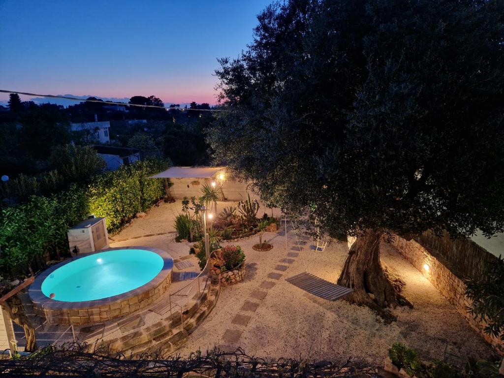 - une vue sur la piscine et un arbre dans l'établissement Villa Anna Polignano, à Polignano a Mare