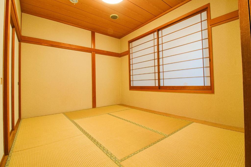 une pièce vide avec une grande fenêtre dans une pièce dans l'établissement Hotel Kinu, à Nikkō