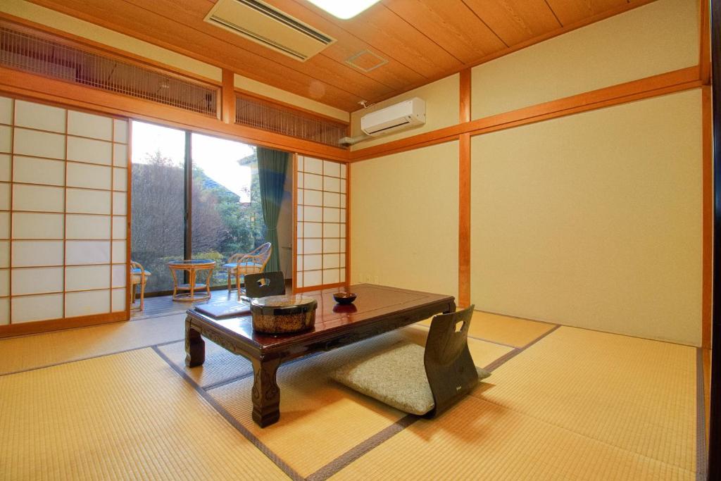 Cette chambre comprend une table et une chaise. dans l'établissement Hotel Kinu, à Nikkō