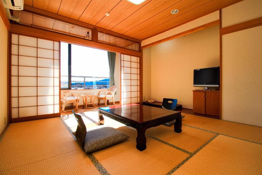 un salon avec une table et une télévision dans l'établissement Hotel Kinu, à Nikkō