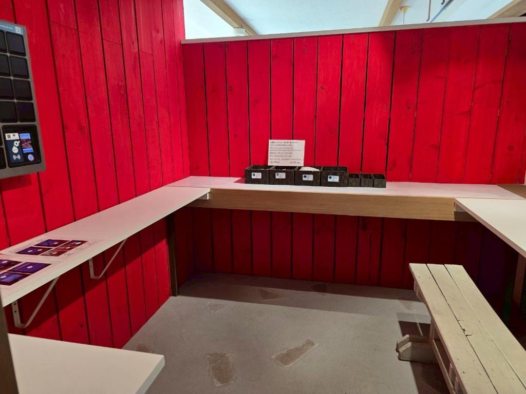 Cette chambre est dotée de murs rouges et d'un mur rouge. dans l'établissement Auberge Ninguruforet, à Biei