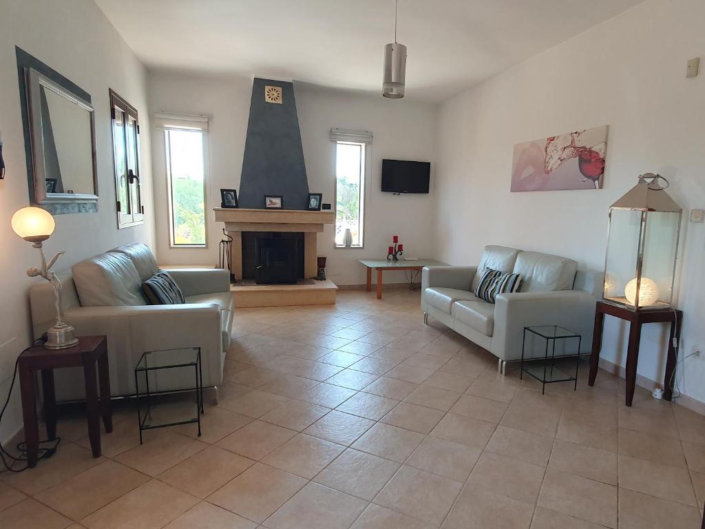 un salon avec deux canapés et une cheminée dans l'établissement Villa Venus, A Countryside Retreat, à San Vito dei Normanni