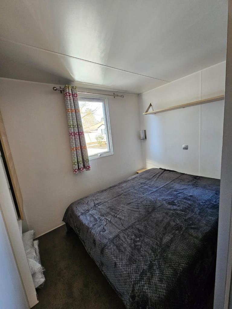 une petite chambre avec un lit et une fenêtre dans l'établissement mobil home, à Villeneuve-lès-Maguelone