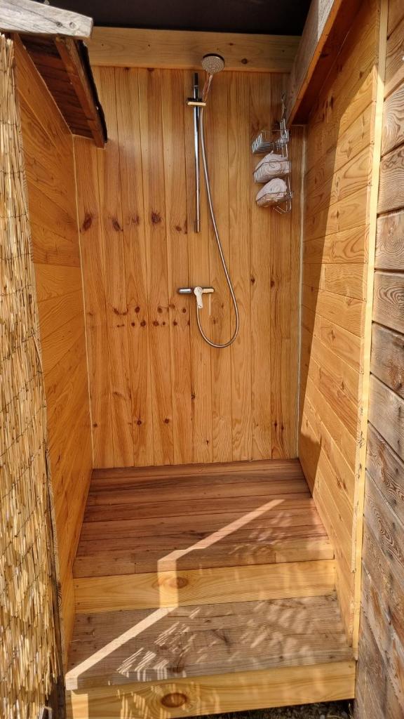 - un sauna en bois avec une douche dans un mur en bois dans l'établissement La bulle ico, à Valensole
