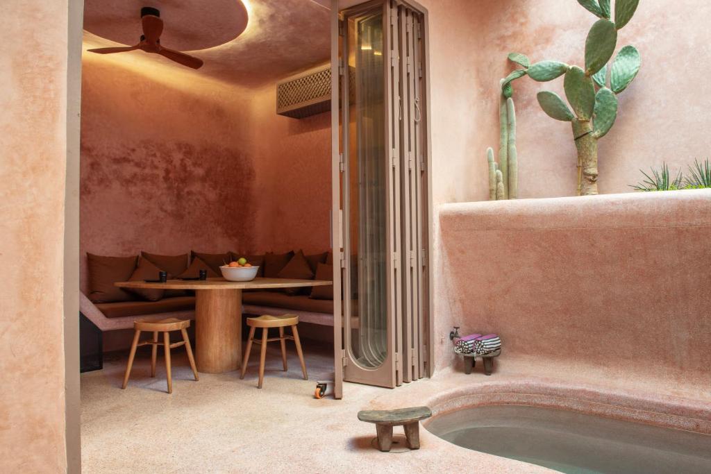 La salle de bains est pourvue d'une baignoire, d'une table et d'une salle à manger. dans l'établissement Riad Brummell Medina, à Marrakech