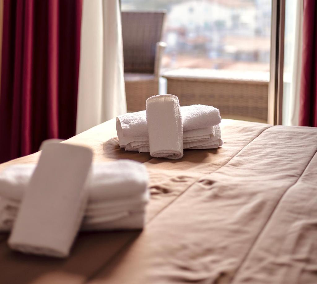 une pile de serviettes posée sur un lit dans l'établissement Hotel Felicioni, à Pineto