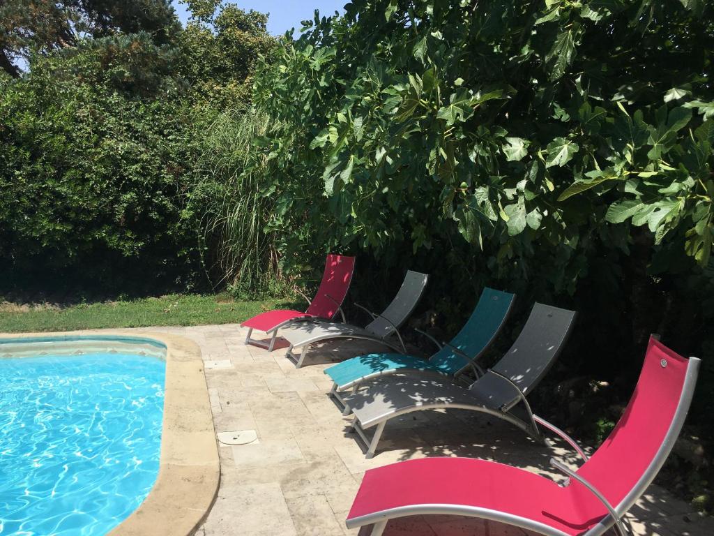 une rangée de chaises de jardin à côté d'une piscine dans l'établissement La Dorépontaise YOURTE MONGOLE, à Pondaurat