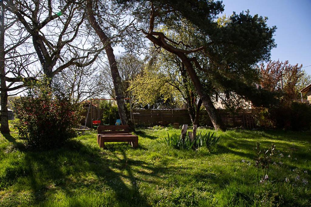 d'un jardin avec un banc dans la pelouse dans l'établissement La Dorépontaise YOURTE MONGOLE, à Pondaurat