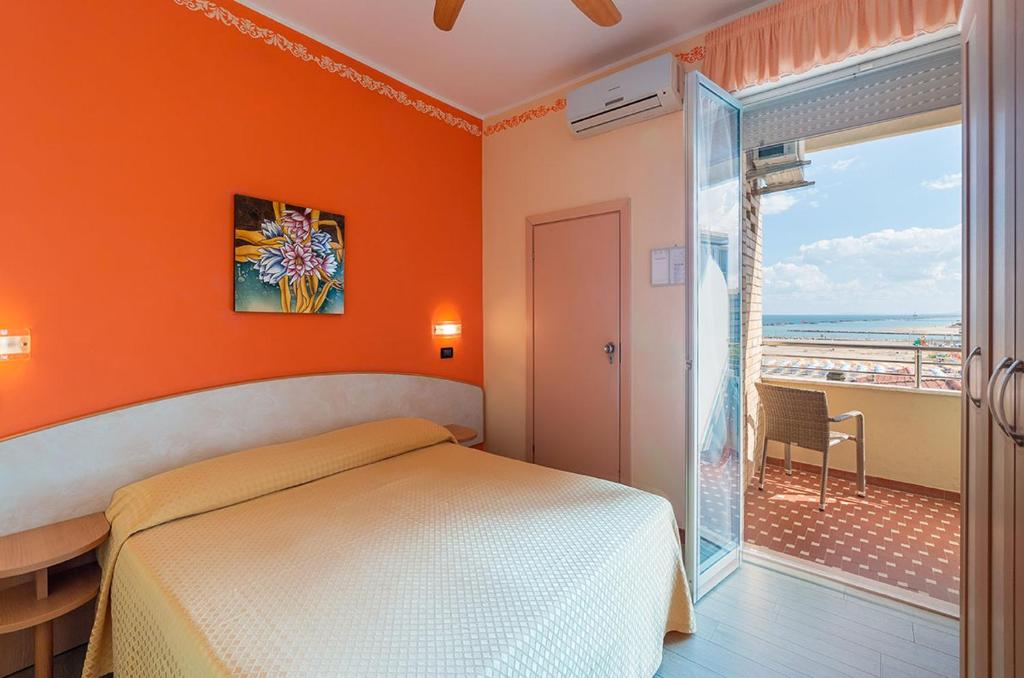 une chambre avec un lit et une vue sur l'océan dans l'établissement Hotel Bamby e Delfino, à Gatteo a Mare