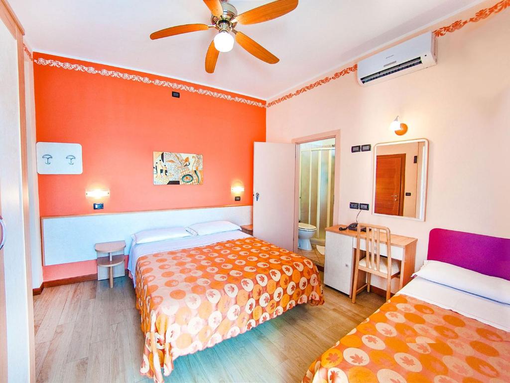 une chambre avec deux lits et un ventilateur de plafond dans l'établissement Hotel Bamby e Delfino, à Gatteo a Mare