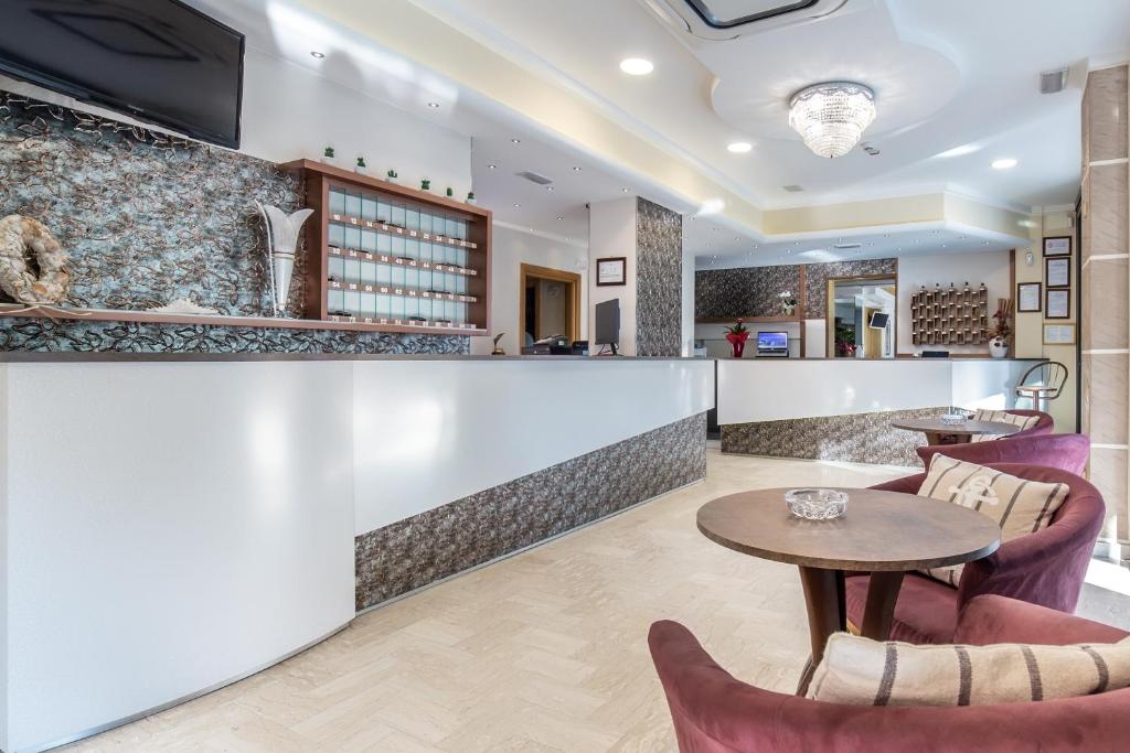 un bar dans un restaurant avec une table et des chaises dans l'établissement Hotel Bamby e Delfino, à Gatteo a Mare 13 autres photos