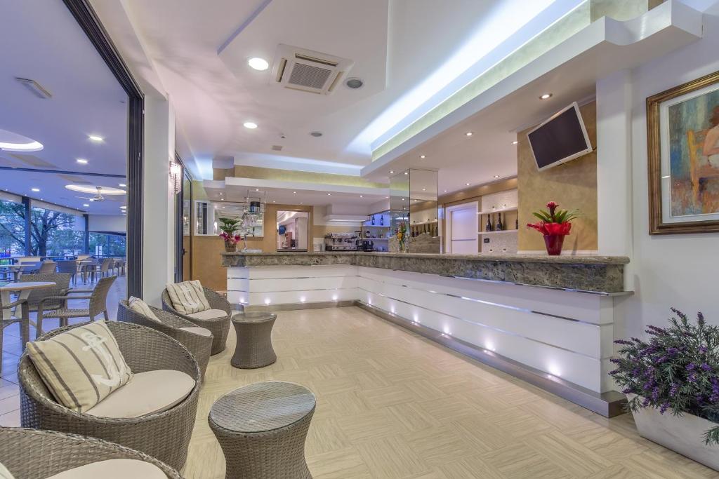 un bar dans un restaurant avec des chaises et un comptoir dans l'établissement Hotel Bamby e Delfino, à Gatteo a Mare