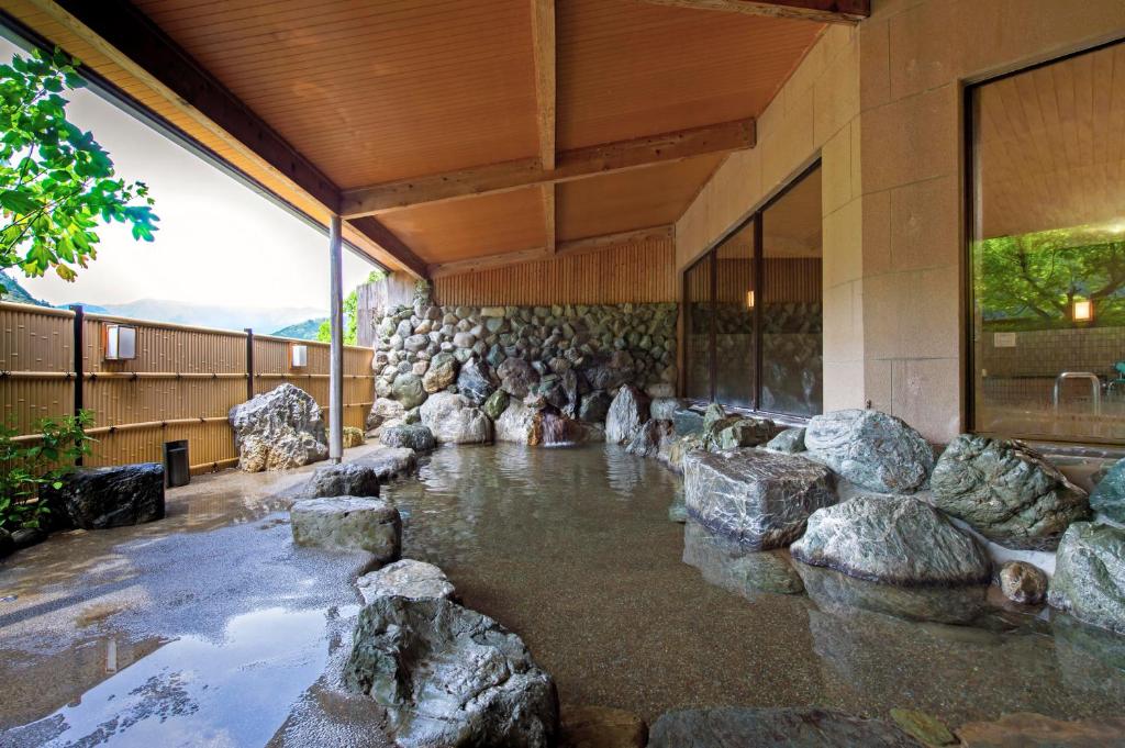 une piscine d'eau avec des rochers devant un bâtiment dans l'établissement Matsusaka Doggie Paradise Hotel Smeall, à Matsuzaka 34 autres photos