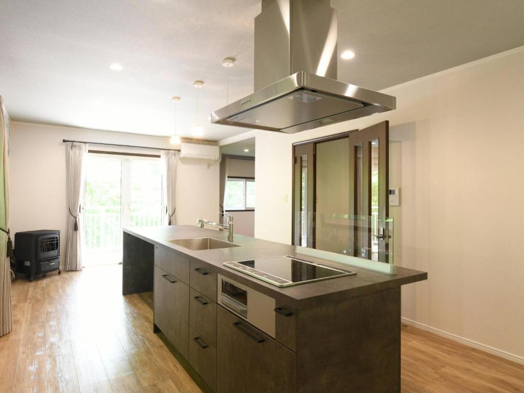 une cuisine avec un évier et une cuisinière dans l'établissement Izumigo AMBIENT Azumino Cottage, à Azumino