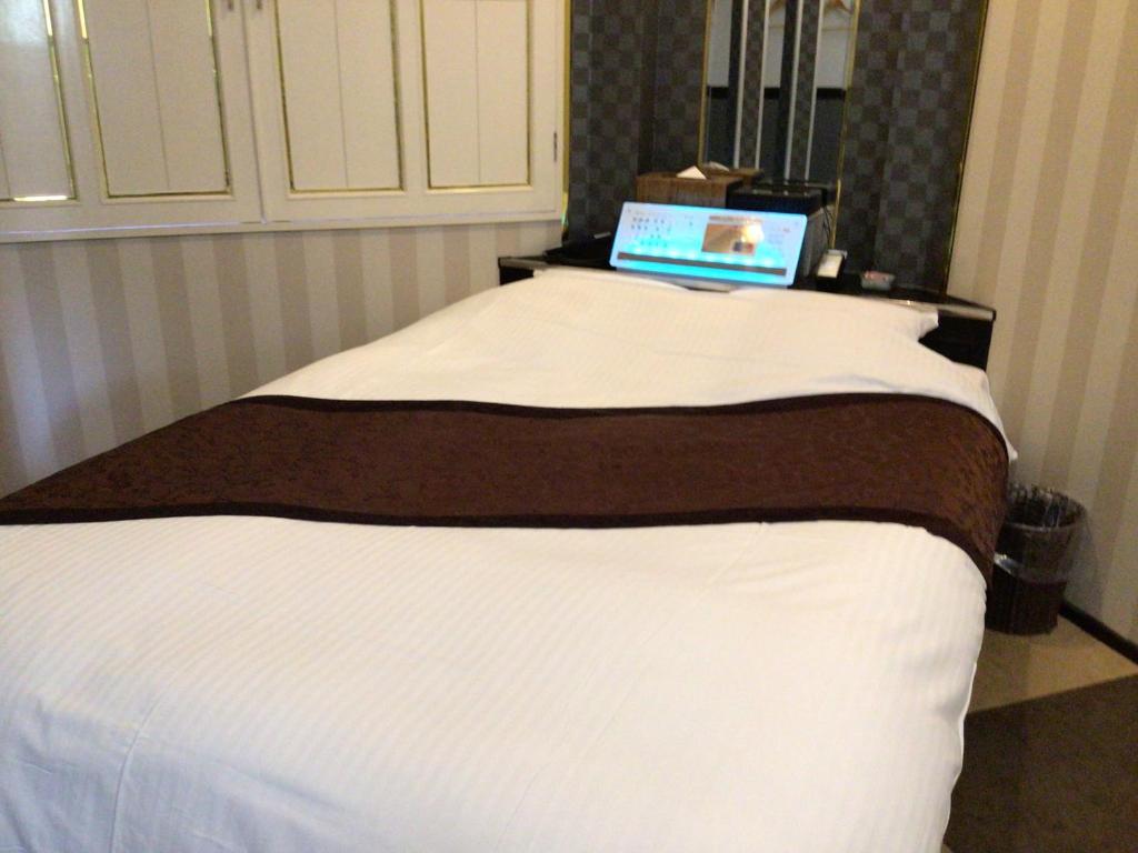un lit avec un ordinateur portable installé au-dessus dans l'établissement ホテルバレンタインb館 ビジネスステイ, à Tottori