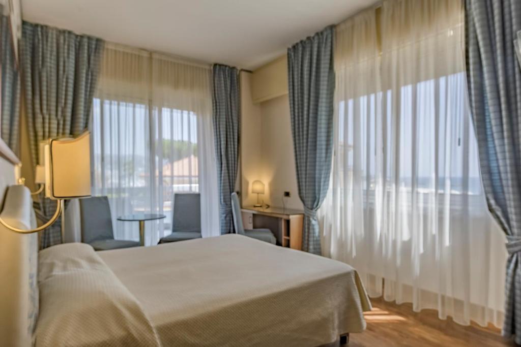 une chambre d'hôtel avec un lit et une grande fenêtre dans l'établissement Hotel Garden Lido, à Loano