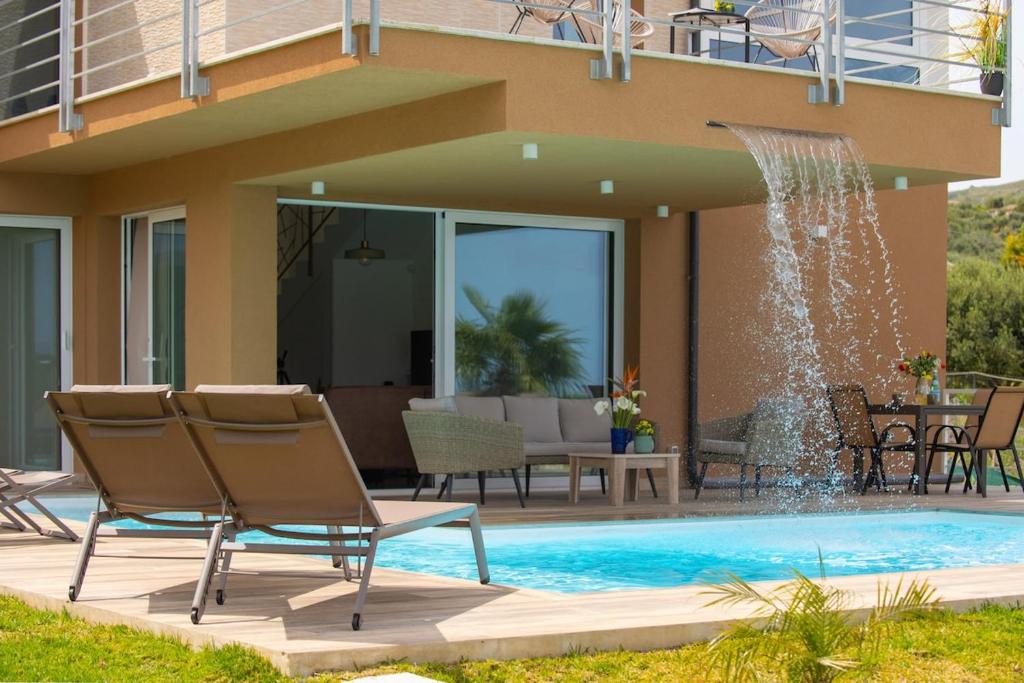 une piscine avec des chaises et une fontaine dans l'établissement Villa Soho, à Balata di Baida