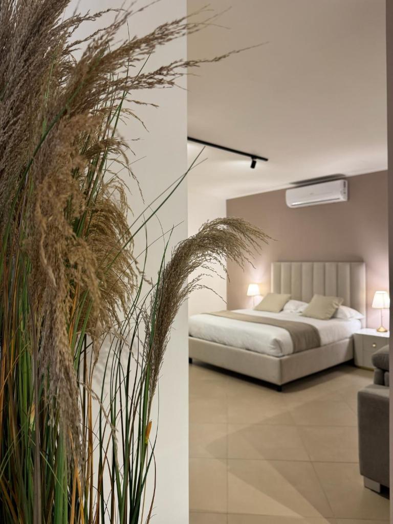 une chambre avec un lit et une plante dans l'établissement Samarè Rooms & Apartments, à Bisceglie 23 autres photos