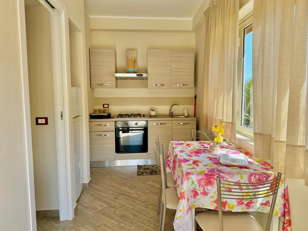 une cuisine avec une table avec une nappe fleurie dans l'établissement Hotel Soleado, à Taormine