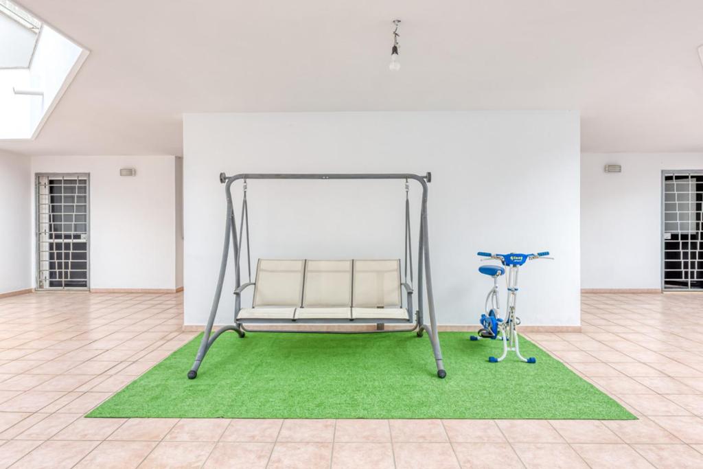 une chambre blanche avec un banc et un tapis vert dans l'établissement Villa Urso, à Ugento