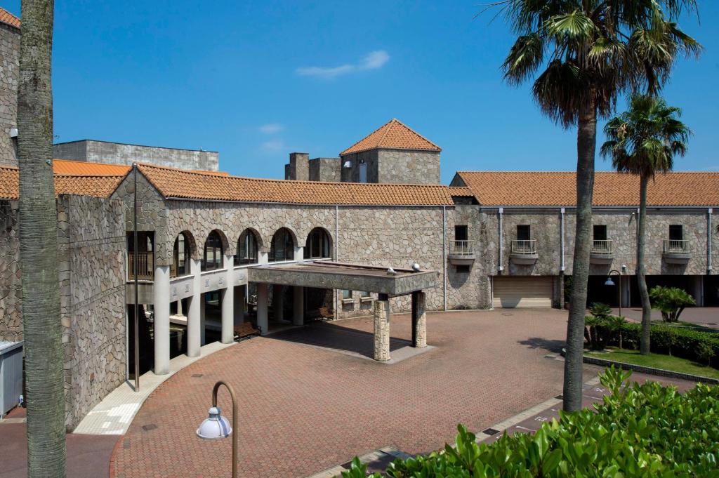 - un bâtiment doté d'une grande cour avec un palmier dans l'établissement Izumigo Hotel Altia Toba, à Toba