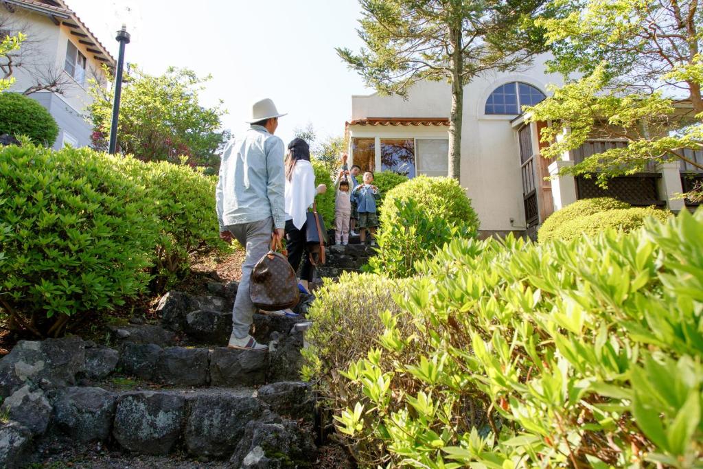 un groupe de personnes debout à l'extérieur d'une maison dans l'établissement Izumigo Izukogen Dog Paradise Hotel & Cottage, à Itō