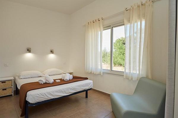 une chambre avec un lit, une chaise et une fenêtre dans l'établissement Camping Domaine d'Anghione, à Castellare-di-Casinca