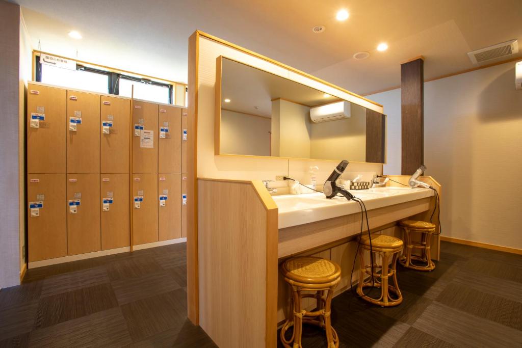 une salle de bain avec deux lavabos et un grand miroir dans l'établissement Yuyaruru Saisai, à Kanazawa