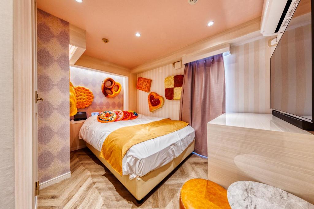 - une petite chambre avec un lit et une télévision dans l'établissement SweetsHotel Ikebukuro -Adult Only, à Tokyo