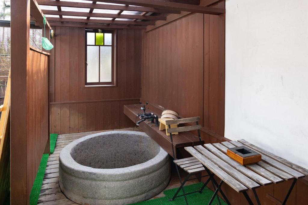 - une grande baignoire dans une chambre avec une table dans l'établissement Hotakajo, à Azumino 14 autres photos