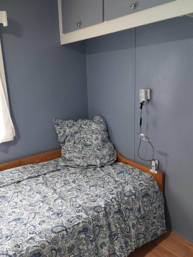 Ce lit se trouve dans une chambre dotée d'un mur bleu. dans l'établissement Mobil home Var, à Méounes-lès-Montrieux