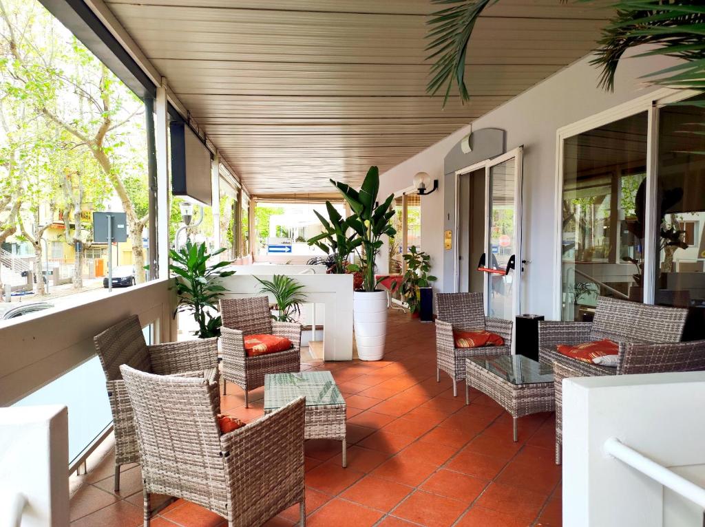 un patio extérieur avec des chaises, des tables et des fenêtres dans l'établissement Hotel Cà Vanni, à Rimini