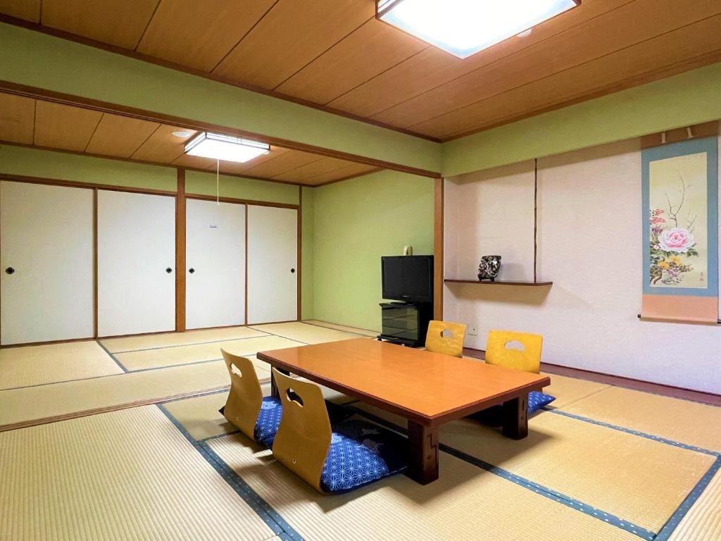 une salle de conférence avec une table et des chaises en bois dans l'établissement Dochu Land Shin Onsen, à Awa
