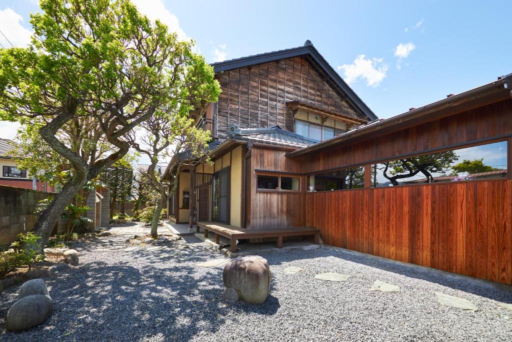 une maison avec une clôture en bois et un banc dans l'établissement 町住客室 秩父宿, à Chichibu
