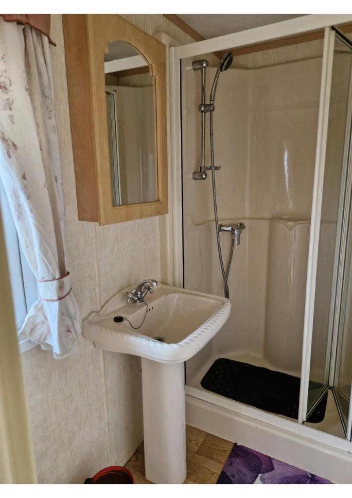 une salle de bain avec un lavabo et une douche dans l'établissement La Sensation, à Matringhem