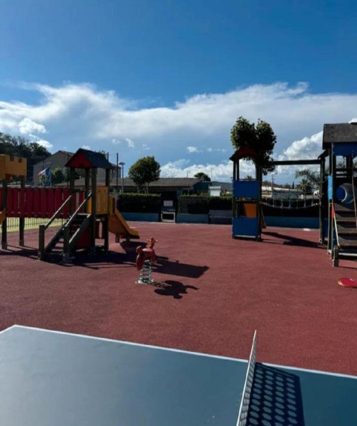 une aire de jeux avec un enfant jouant sur un toboggan dans l'établissement Europcamping, à Fréjus