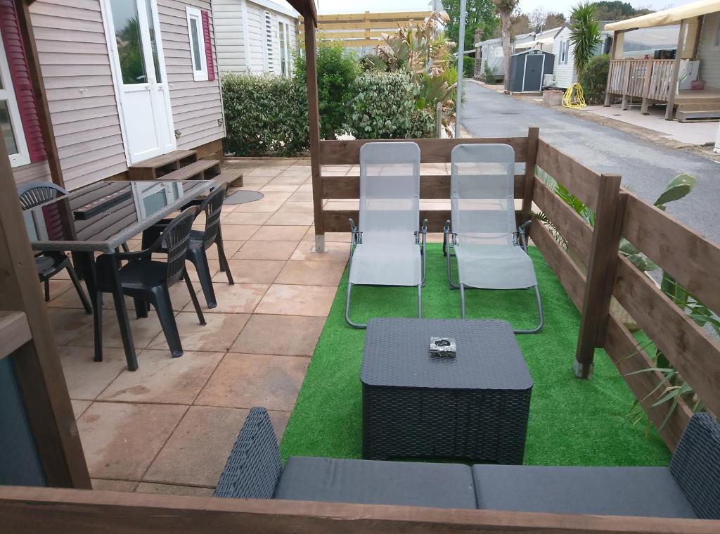 d'une terrasse avec des chaises, une table et de la pelouse. dans l'établissement Europcamping, à Fréjus 12 autres photos