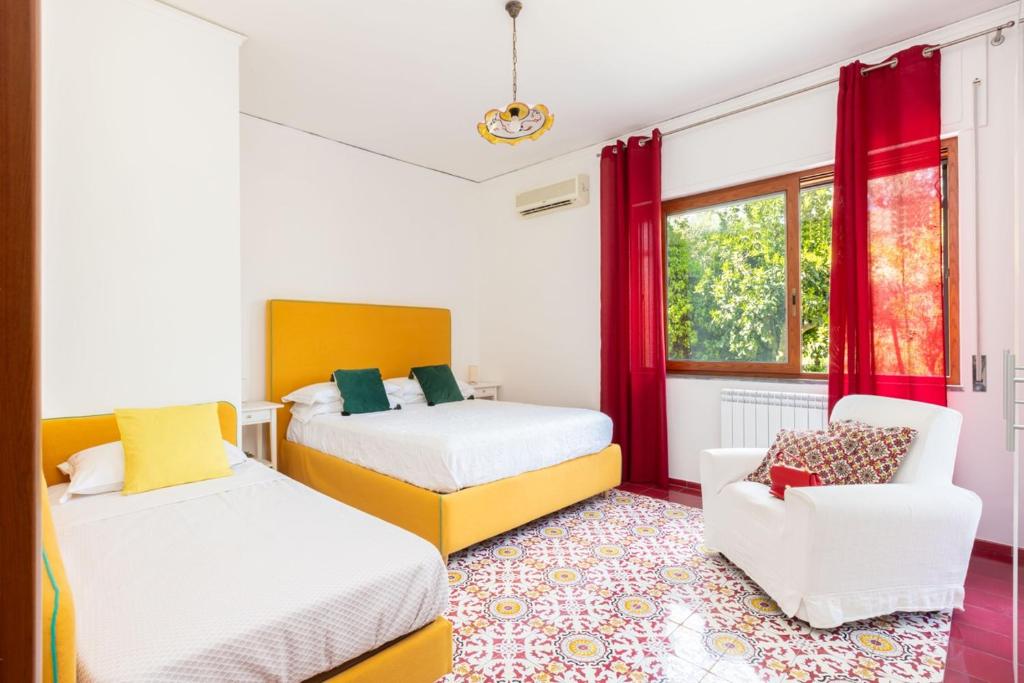 une chambre avec deux lits et une chaise et une fenêtre dans l'établissement Estate4home - Villa Louise, à Sorrente 106 autres photos