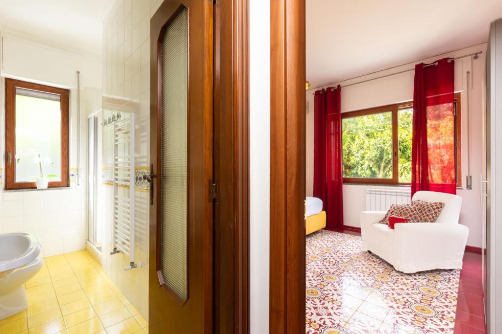 La salle de bains est pourvue de toilettes et d'une chaise. dans l'établissement Estate4home - Villa Louise, à Sorrente