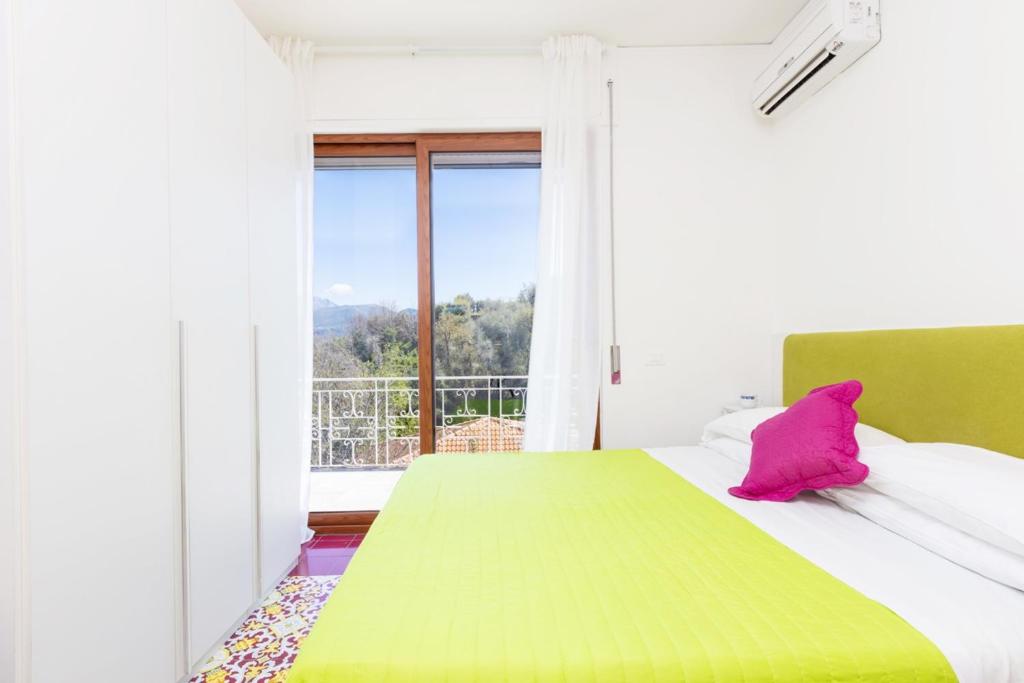 - une chambre avec un lit vert et blanc et une fenêtre dans l'établissement Estate4home - Villa Louise, à Sorrente