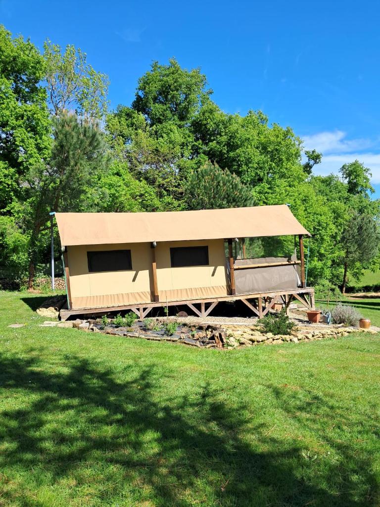 un bâtiment avec un toit sur un terrain en herbe dans l'établissement O'PHIL DE LAU, à Manciet