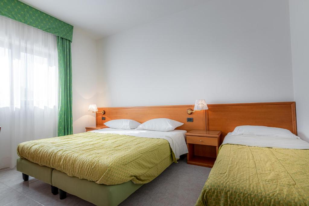 une chambre avec deux lits et une fenêtre dans l'établissement Hotel A' CAPANNA, à Diamante