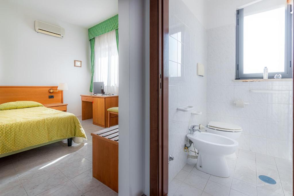 une chambre avec un lit et une salle de bain avec WC dans l'établissement Hotel A' CAPANNA, à Diamante